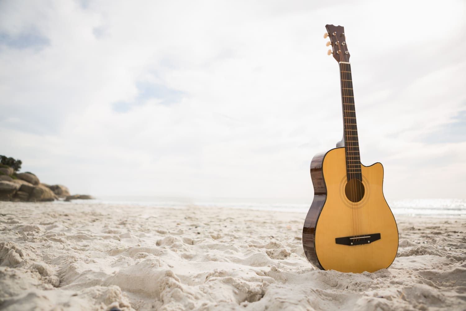 guitare posée sur le sable à la plage